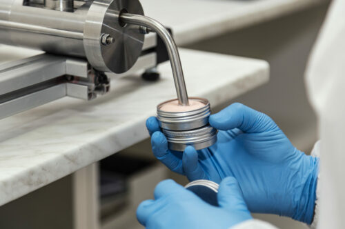Close up of human hands working at cosmetic factory, medical products