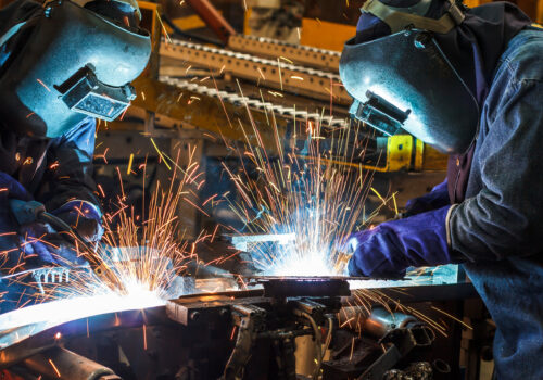 worker with protective mask welding metal