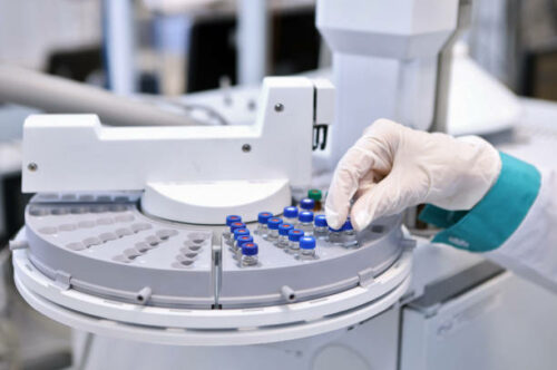 Quality Control Laboratory medicine. Chromatograph operation. A woman makes an analysis on a gas chromatograph. Development of a new vaccine against the covid-19 virus.Pharmaceutical factory